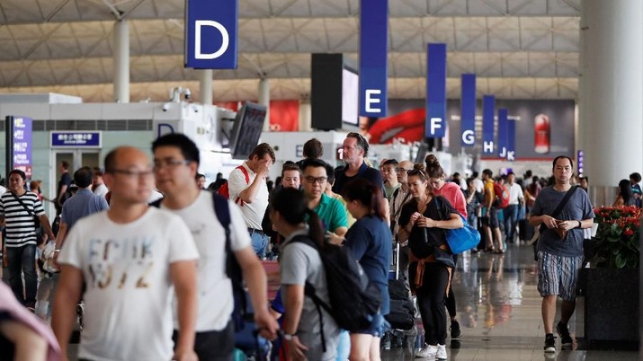 Foto: Penumpang mengantri di konter check-in ketika bandara dibuka kembali sehari setelah penerbangan dihentikan karena protes, di Bandara Internasional Hong Kong, Cina 13 Agustus