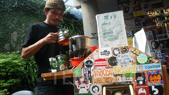 Angga, meracik kopi untuk pelanggannya di Bandung, Jawa Barat, 11 Maret 2022. Angga berjualan kopi menggunakan sepeda yang mangkal setiap hari di trotoar Jalan Taman Cibeunying. TEMPO/Prima mulia