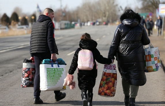 Para pengungsi Ukrania terlihat berjalan untuk melarikan diri ke Hungaria, setelah Rusia melancarkan operasi militer besar-besaran. /Reuters/Bernadett Szabo/