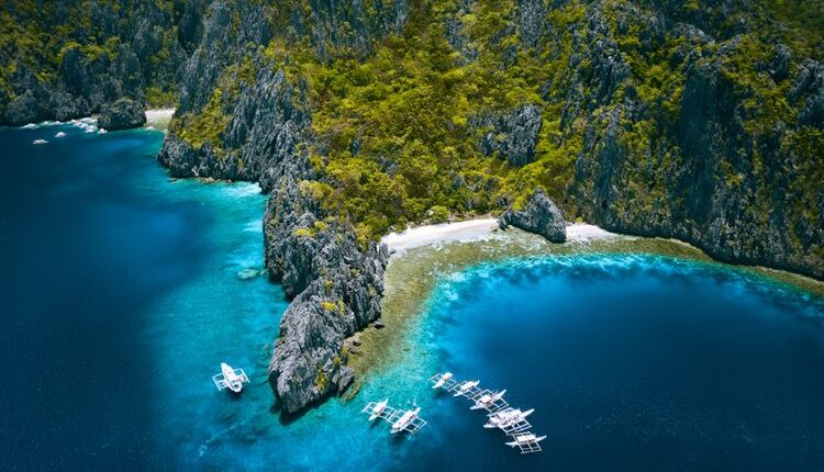 Pemandangan udara Pulau Miniloc, El Nido, Palawan, Filipina dengan perahu selam di atas terumbu karang yang dikelilingi oleh tebing gunung berbatu kapur karst. Wisata bahari di Filipina menjadi salah satu daya tarik bagi wisatawan asing.(SHU/IGOR TICHONOW)