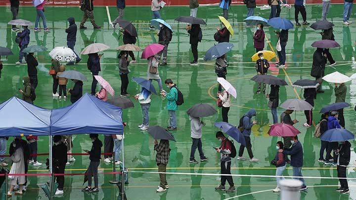 Puluhan warga mengantre memakai masker saat berada di pusat pengujian darurat COVID-19 di Hong Kong, 17 Februari 2022. Otoritas kesehatan melaporkan rekor 6.116 kasus yang dikonfirmasi pada hari Kamis, naik dari 4.285 pada hari sebelumnya. REUTERS/Lam Yik