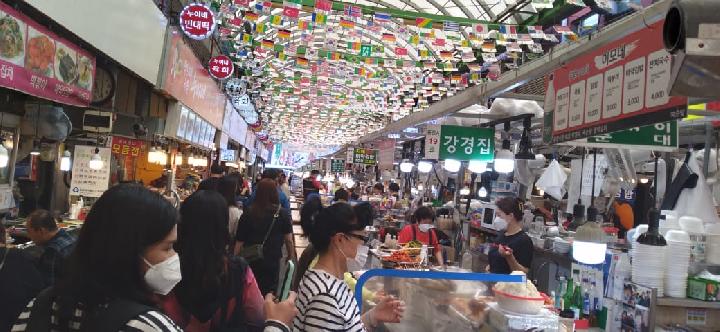 Pasar Kwan Jang di Seoul, Korea Selatan pada Senin, 6 Juni 2022, yang sudah dipadati. Warga tetap menggunakan masker, dan cairan pembersih tangan disediakan di gerbang masuk pasar, namun sudah tidak ada social distancing. Sumber: Suci Sekar/TEMPO