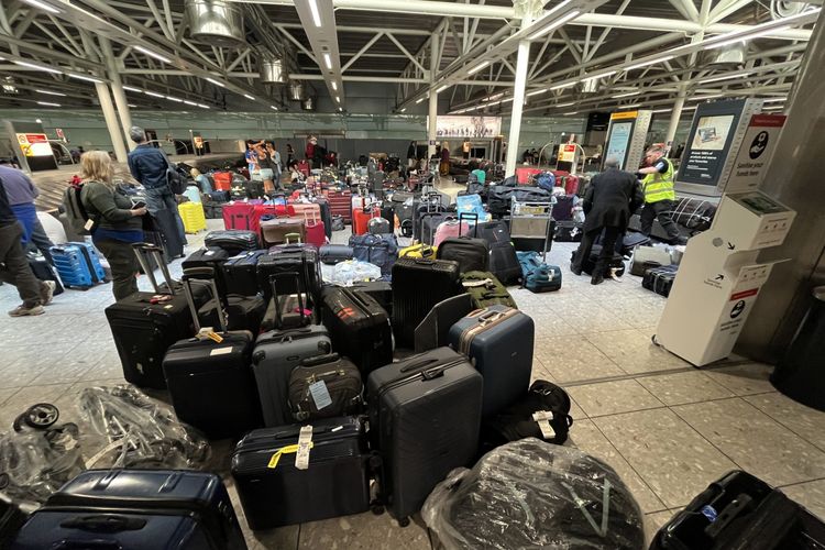 Koper-koper memadati tempat pengambilan bagasi di Terminal Tiga Bandara Heathrow, London, Inggris, (08/07/2022).(AFP/PAUL ELLIS)