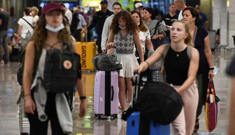 Para penumpang pesawat terbang sedang berjalan di Terminal 2 Bandara El Prat di Barcelona, Spanyol. Pada periode musim panas terjadi kenaikan angka lalu lintas penerbangan.(AFP/PAU BARRENA)