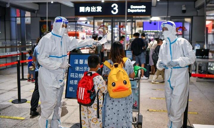 Turis yang terdampar di tengah wabah baru penyakit coronavirus (COVID-19) tiba di aula keberangkatan Bandara Internasional Haikou Meilan di Haikou, provinsi Hainan, China 11 Agustus 2022. cnsphoto via REUTERS