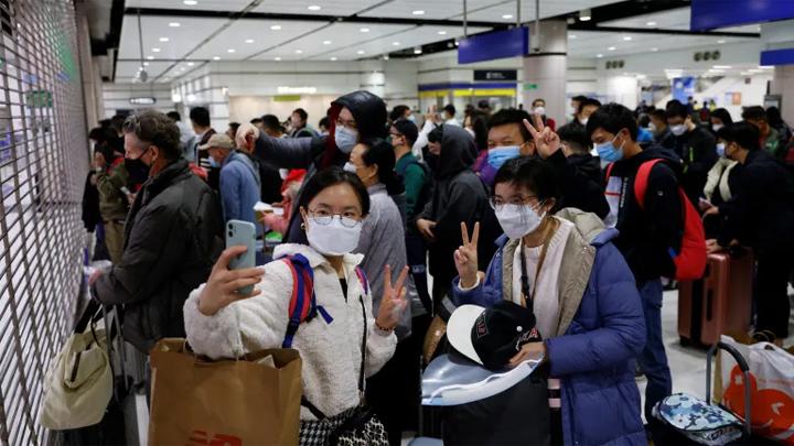 Wisatawan berpose untuk foto di gerbang pos pemeriksaan perbatasan Lok Ma Chau Hong Kong sebelum China membuka kembali perbatasan. Tyrone Siu/Reuters