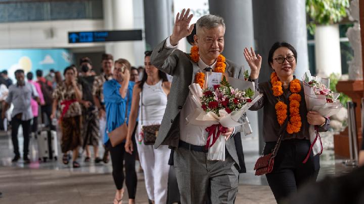 Sejumlah turis berjalan keluar dari Bandar Udara Internasional Ngurah Rai di Bali pada 22 Januari 2023. Bali menerima penerbangan langsung pertama dari Cina sejak merebaknya pandemi pada awal 2020, menandakan dilanjutkan kembali penerbangan langsung reguler antara sejumlah kota di Cina dan Bali dalam waktu dekat. (Xinhua/Dicky Bisinglasi)