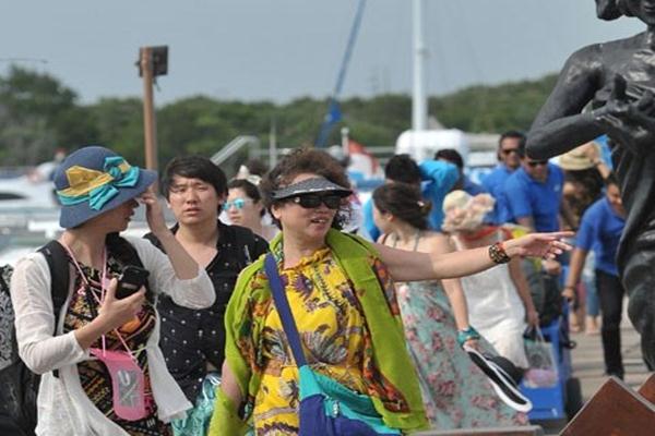 Sejumlah wisatawan melihat patung nelayan setibanya mereka dari berwisata dengan kapal laut di dermaga Serangan, Denpasar. - Antara