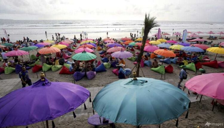 Foto : AP Photo/Firdia Lisnawati Wisatawan menghabiskan waktu di pantai Kuta, Bali. Banyak orang Ukraina dan Rusia telah menjadikan pulau resor ini sebagai tujuan mereka berlindung.