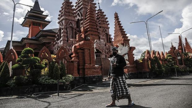 Foto: Pecalang Bali berpatroli di luar bandara internasional Ngurah Rai di Badung, Bali. (NurPhoto via Getty Images)