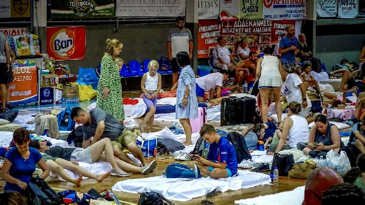 Turis berlindung di stadion setelah dievakuasi menyusul kebakaran hutan di pulau Rhodes, Yunani, 23 Juli 2023. Argiris Mantikos/Eurokinissi via REUTERS