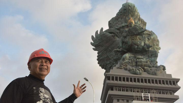 Pemrakarsa Patung Garuda Wisnu Kencana (GWK) Nyoman Nuarta berfoto dengan latar belakang Patung GWK di Ungasan, Badung, Bali, Selasa (31/7). ANTARA